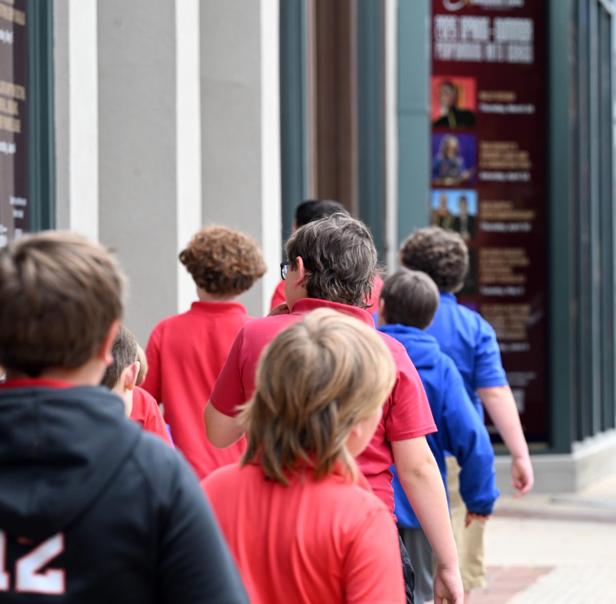 A line of young students walking into the MSU Riley Center for an educational program.