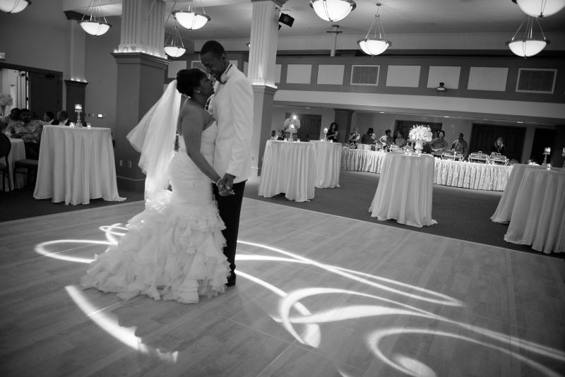 Wide shot of a bride and groom dancing during their wedding reception in the beautifully decorated MSU Riley Center Exhibit Hall.